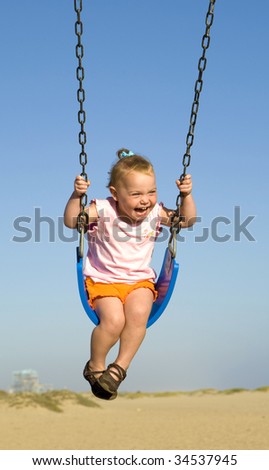 Toddler at the beach on a swing