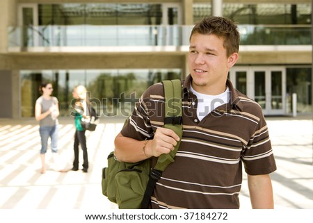 Young man at school holding a book bag