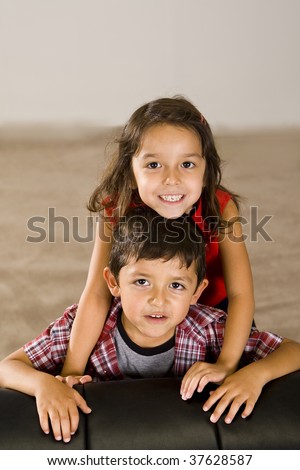 Cute brother and sister sitting on a couch