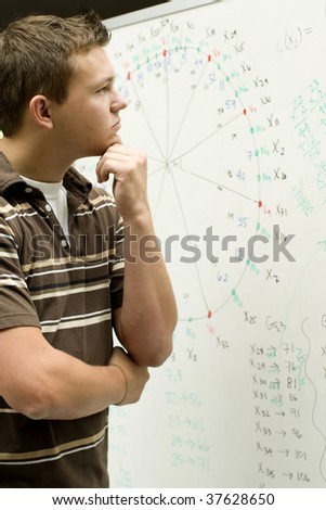 Young man at school doing a math equation