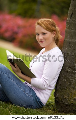 Young woman sitting outside reading