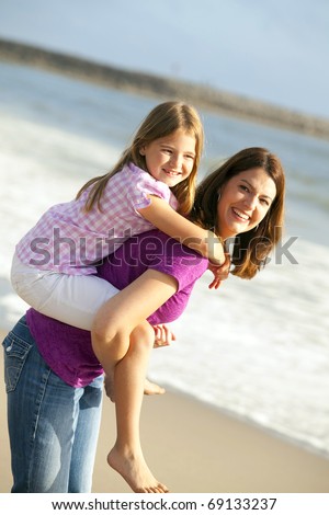 Loving mother and daughter playing on the beach
