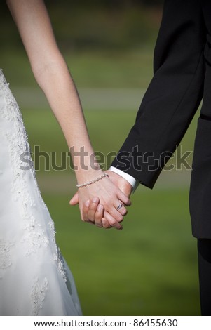 Closeup of Bride and groom holding hands
