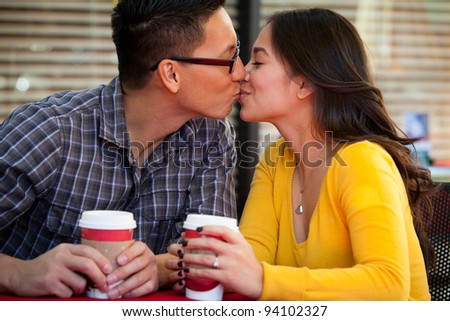 Happy young couple drinking coffee outside cafe