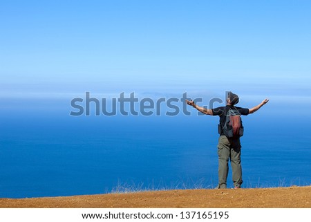 Man looking over a cliff on a hike