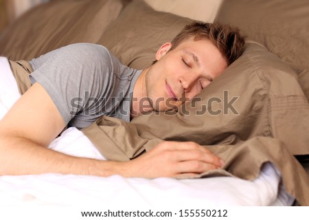 Young Man Comfortably Sleeping In His Bed