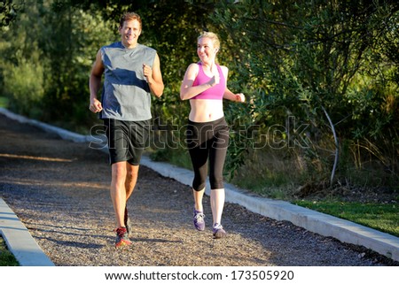 Fit man and woman running together