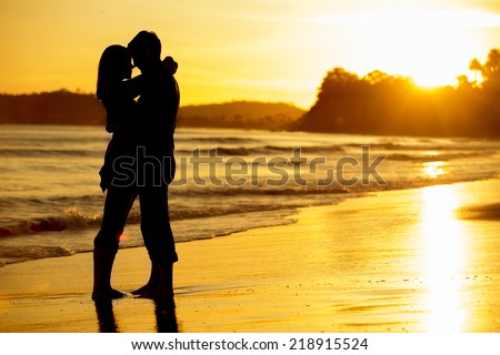 Silhouette of a couple on the beach at sunset
