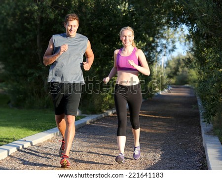 Happy couple running on a trail outside