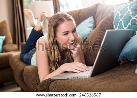 Young woman looking at her laptop on the couch