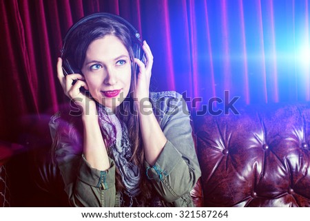 Woman listening to headphones in a club