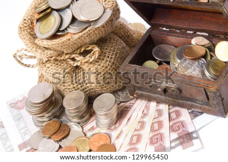 money coins in bag and wooden chest isolated on white