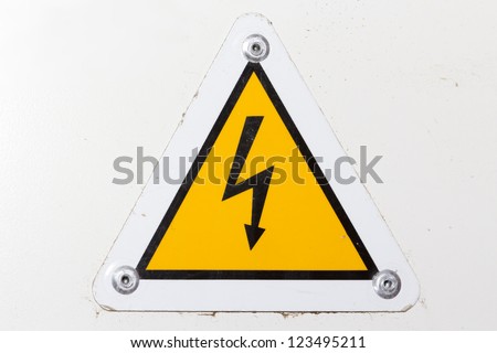 A photo of a high voltage sign on a white wall