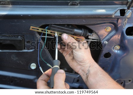 Mechanic installing car central door lock motor