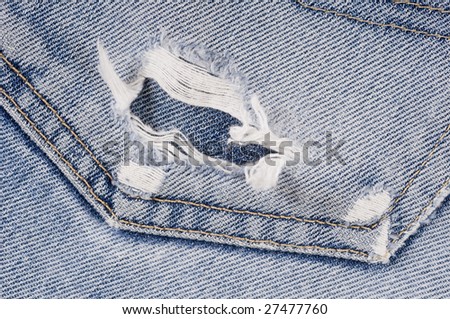 Close up of blue jeans with hole and dirt