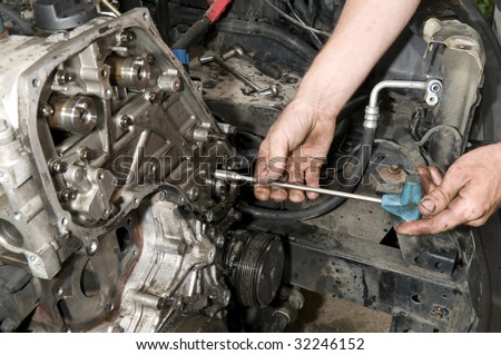 Repairing of diesel engine close up of worker hands