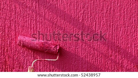 Painting of red wall with paint roller