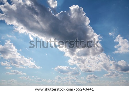 White and black clouds on blue sky  with sun beams