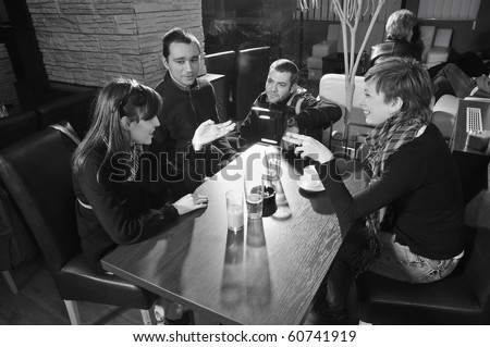 Young people sitting in cafe and talking