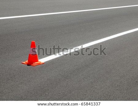 Fresh painted line at asphalt road and traffic cone