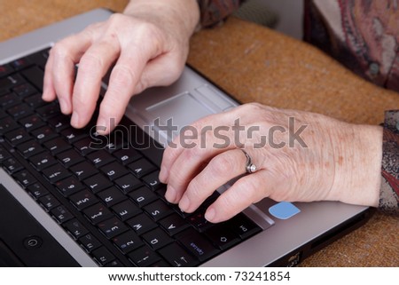 Hands of an old  woman on a computer keyboard