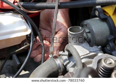 Repairing water pump of modern  engine, workers hands and tool