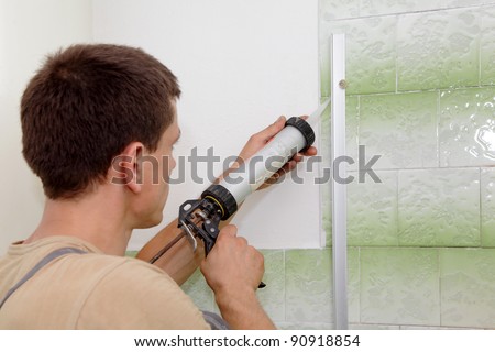Plumber using silicone cartridge for fixing aluminum batten of shower cabin
