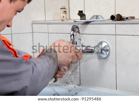 Plumber  fixing water  tap with leaking water