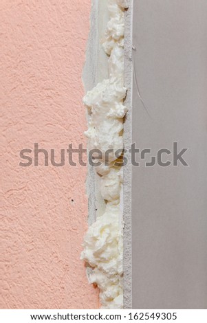 Closeup of gypsum board fixed with polyurethane expanding foam glue