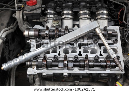 Fixing cylinder head with camshaft of car engine with socket wrench