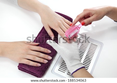 Finger nail treatment, brushing dust from fingers in beauty salon