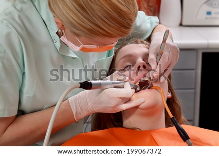Dentist  drilling  tooth of a young patient, closeup, real people