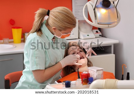 Dentist  examine  tooth of a young patient using tools, real people