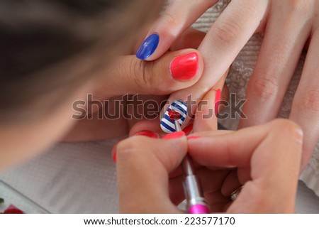 Finger nail treatment, painting heart with brush and lacquer