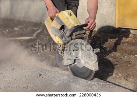 Asphalt or concrete cutting with saw blade at construction site