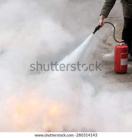 A woman demonstrating how to use a fire extinguisher