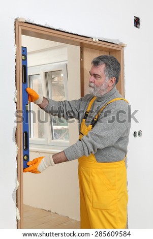 Home renovation, worker install door, using level tool for measure