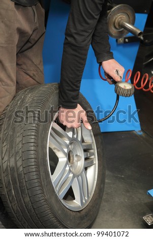 Checking the air pressure in a tire with a pressure gauge