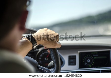 Generic photo of man driving a car through slight turn.