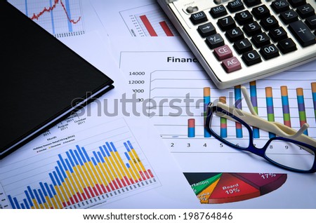 business charts and graphs with eye glass and book note