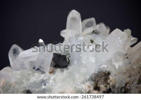 White quartz crystal block formation macro image focused on dark grey deep artistic background with vignette effect symbolizing irregular generative pattern growth and mineral body development