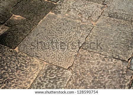 Carved, tooled stone walkway in an ancient temple ruin at Angkor Wat in Siem Reap, Cambodia