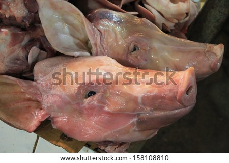 Smiling pig heads for sale at a meat market in Siem Reap, Cambodia, near Angkor Wat