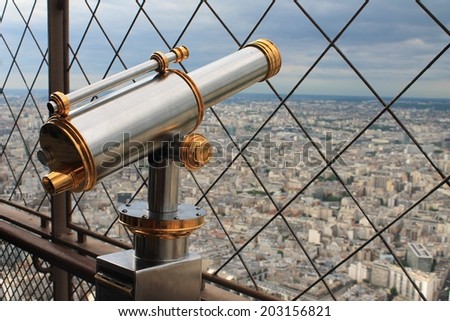 Vintage telescope surveying the view of Paris from atop the Eiffel Tower
