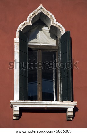 Beautiful Venetian windows open in a red wall