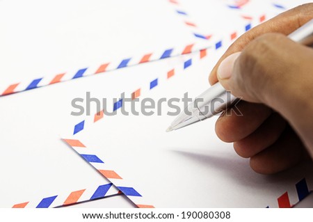 male hand holding a pen to write on the envelope