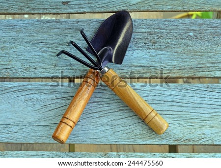 Shovel and gardening fork on wooden background