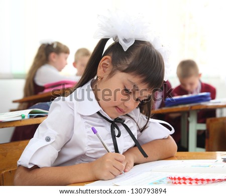 the girl at the desk writing in a notebook