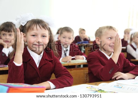 young students wanting to raise their hand to answer