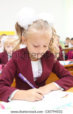 the girl at the desk writing in a notebook